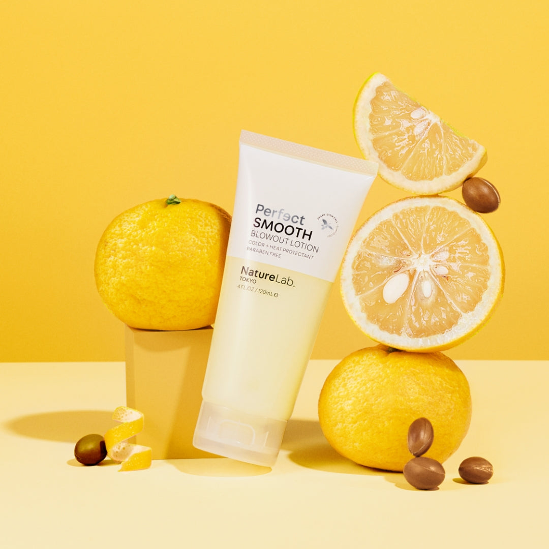 Smooth Blowout Lotion on yellow background with yuzu.