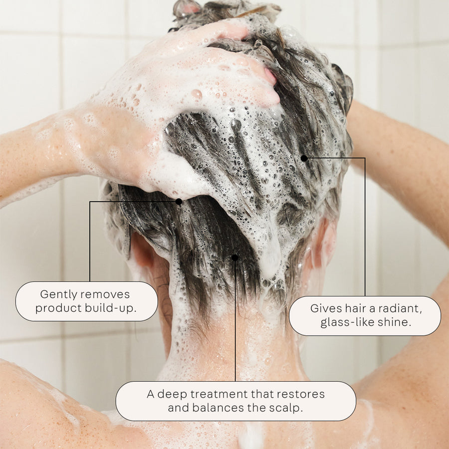 Model washing hair in shower with Clean 2-In-1-Scalp Scrub+ Shampoo.